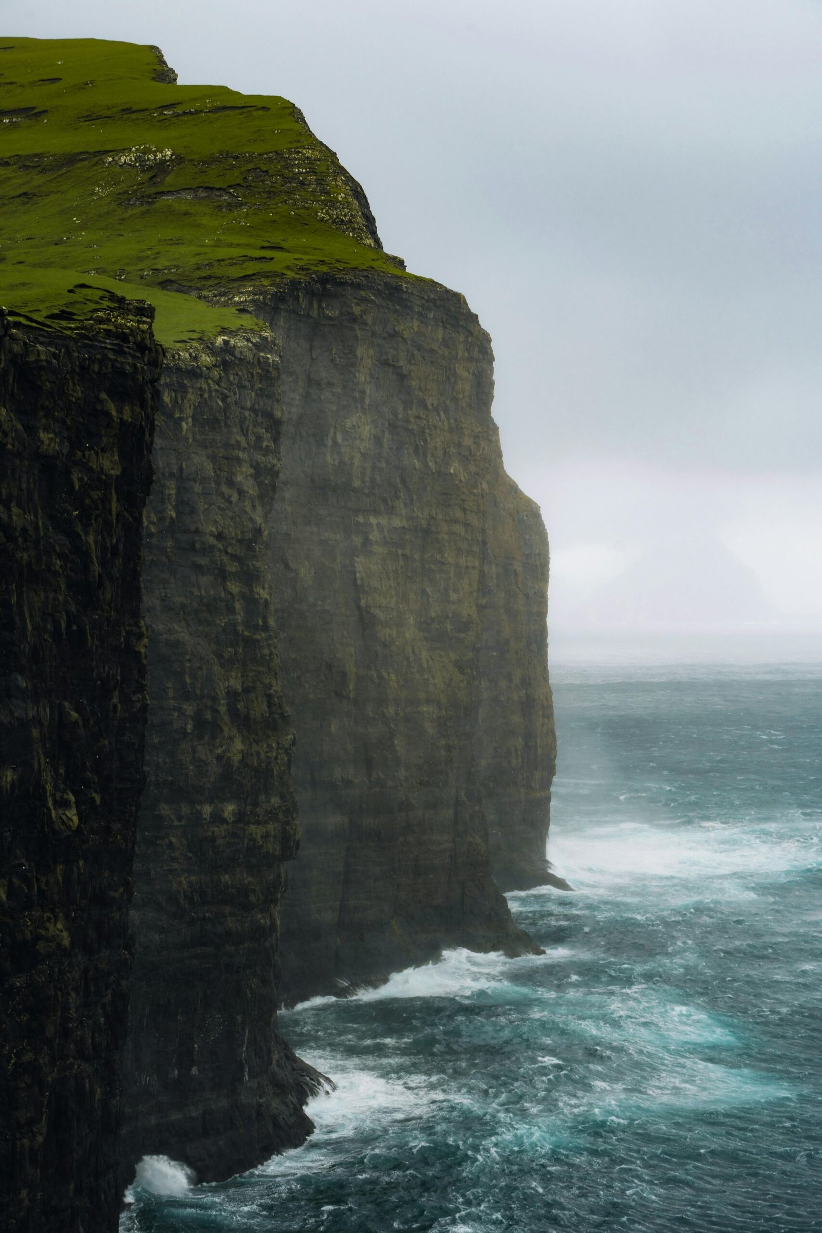 Majestic cliffs with a cloudy sky and ocean view in the Faroe Islands.